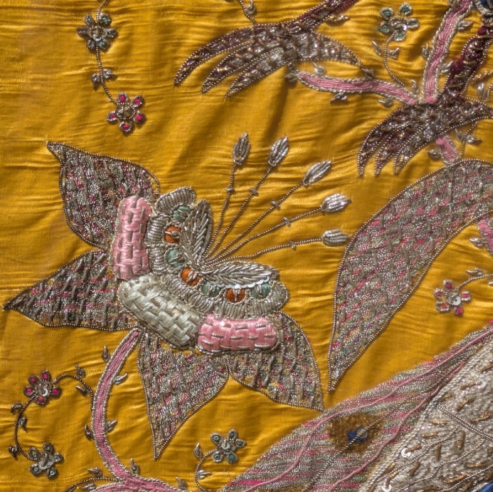Framed vertical yellow silk panel embroidered with two peacocks, floral motifs, and an architectural depiction of the Taj Mahal in metallic thread. View VII