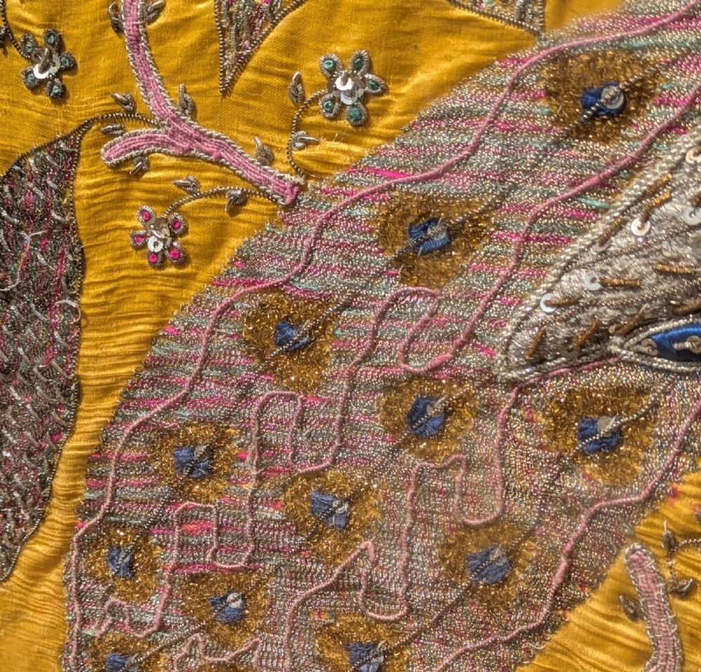 Framed vertical yellow silk panel embroidered with two peacocks, floral motifs, and an architectural depiction of the Taj Mahal in metallic thread. View XI