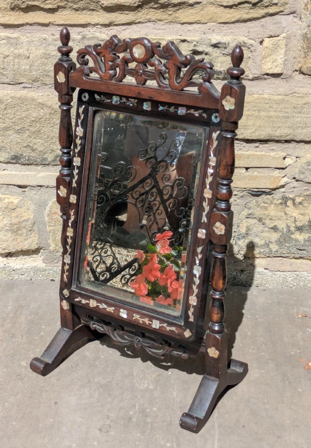 A dark hardwood tabletop cheval mirror featuring floral mother-of-pearl inlay, turned uprights, and a carved cresting top. View II