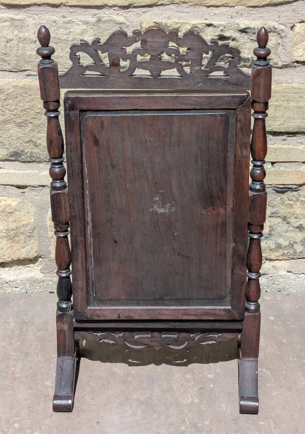 A dark hardwood tabletop cheval mirror featuring floral mother-of-pearl inlay, turned uprights, and a carved cresting top. View VII
