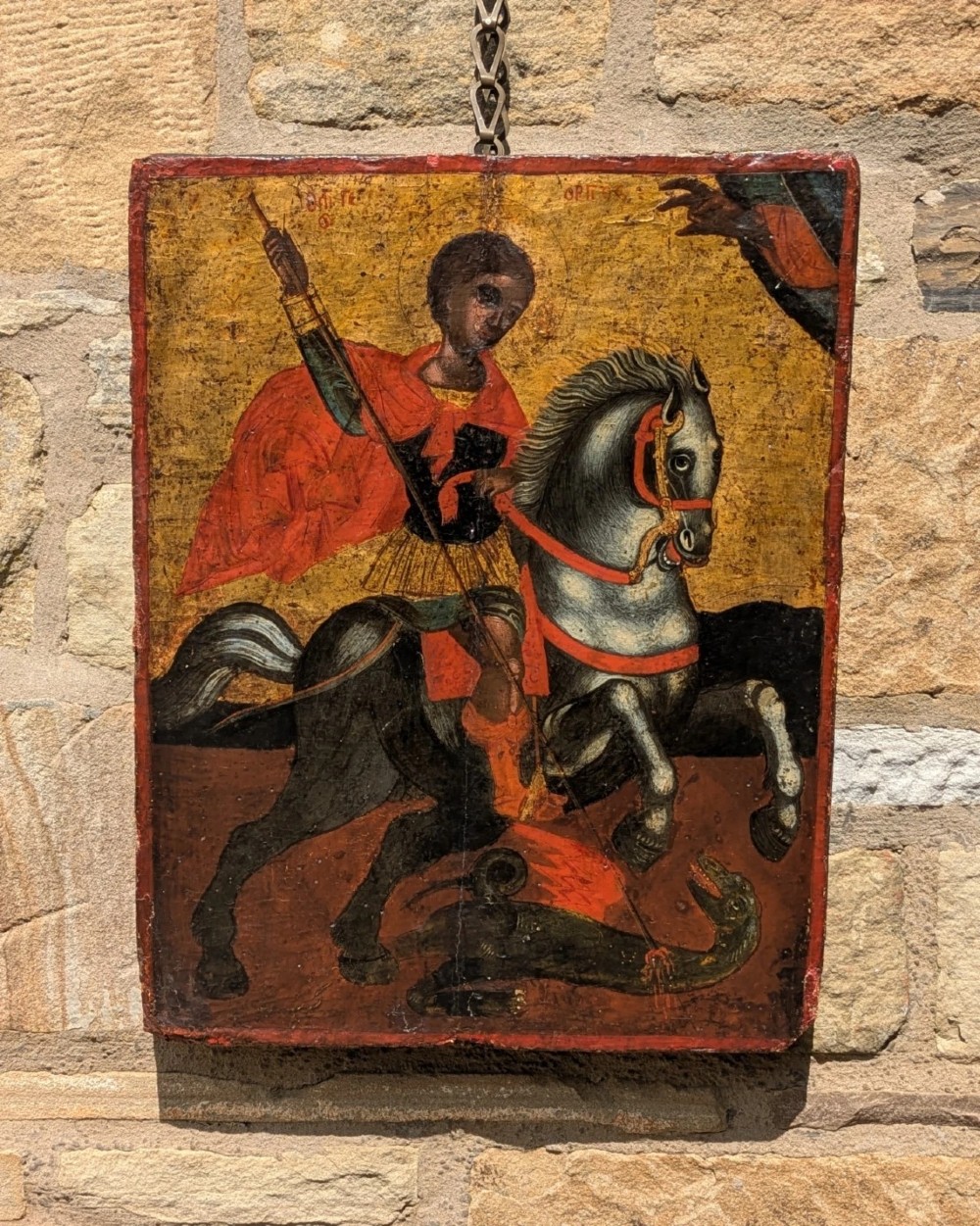 An 18th-century painted wooden icon depicting Saint George on horseback slaying a dragon against a gilded gold leaf background. View V