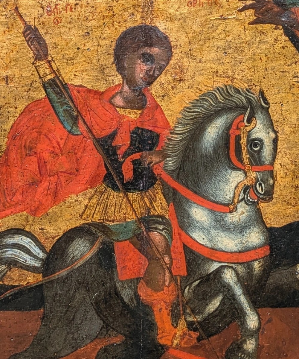 An 18th-century painted wooden icon depicting Saint George on horseback slaying a dragon against a gilded gold leaf background. View VI