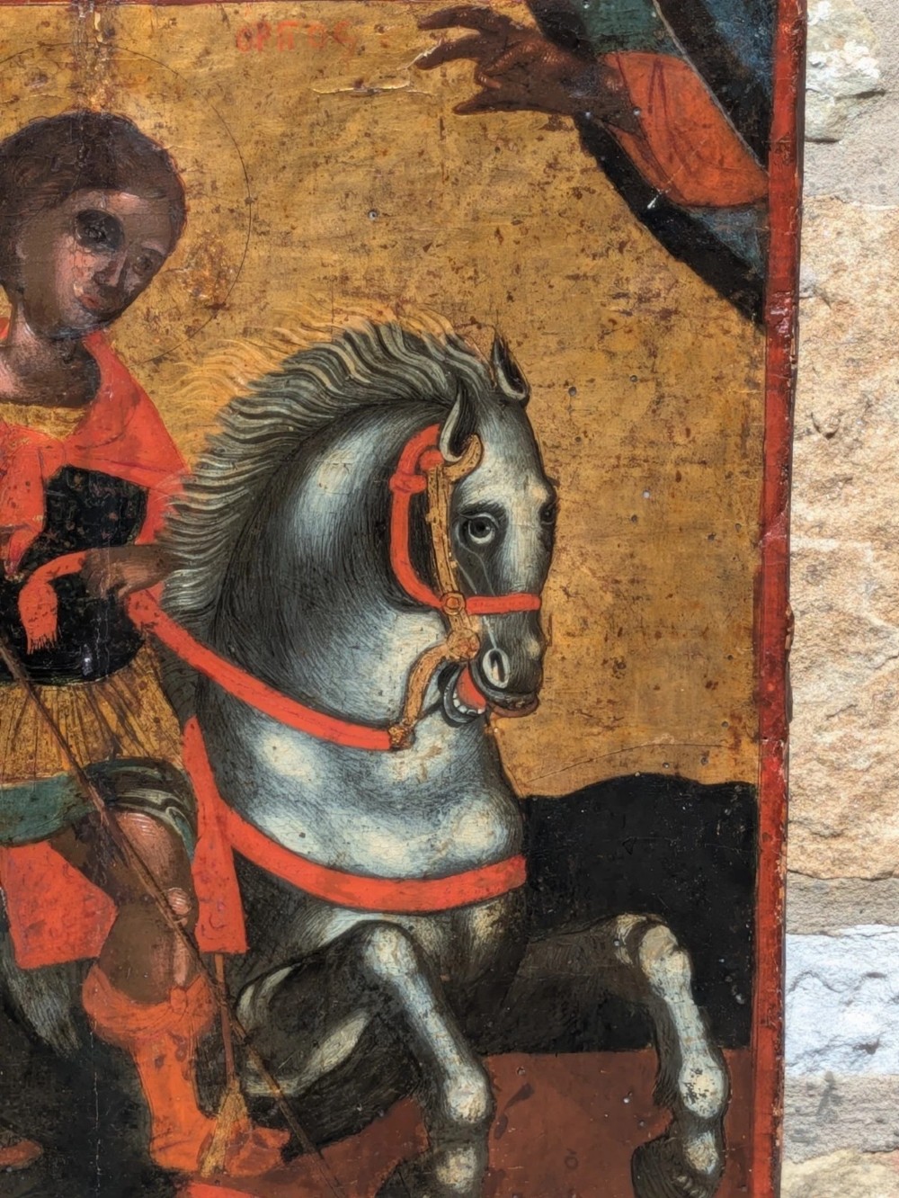 An 18th-century painted wooden icon depicting Saint George on horseback slaying a dragon against a gilded gold leaf background. View IX