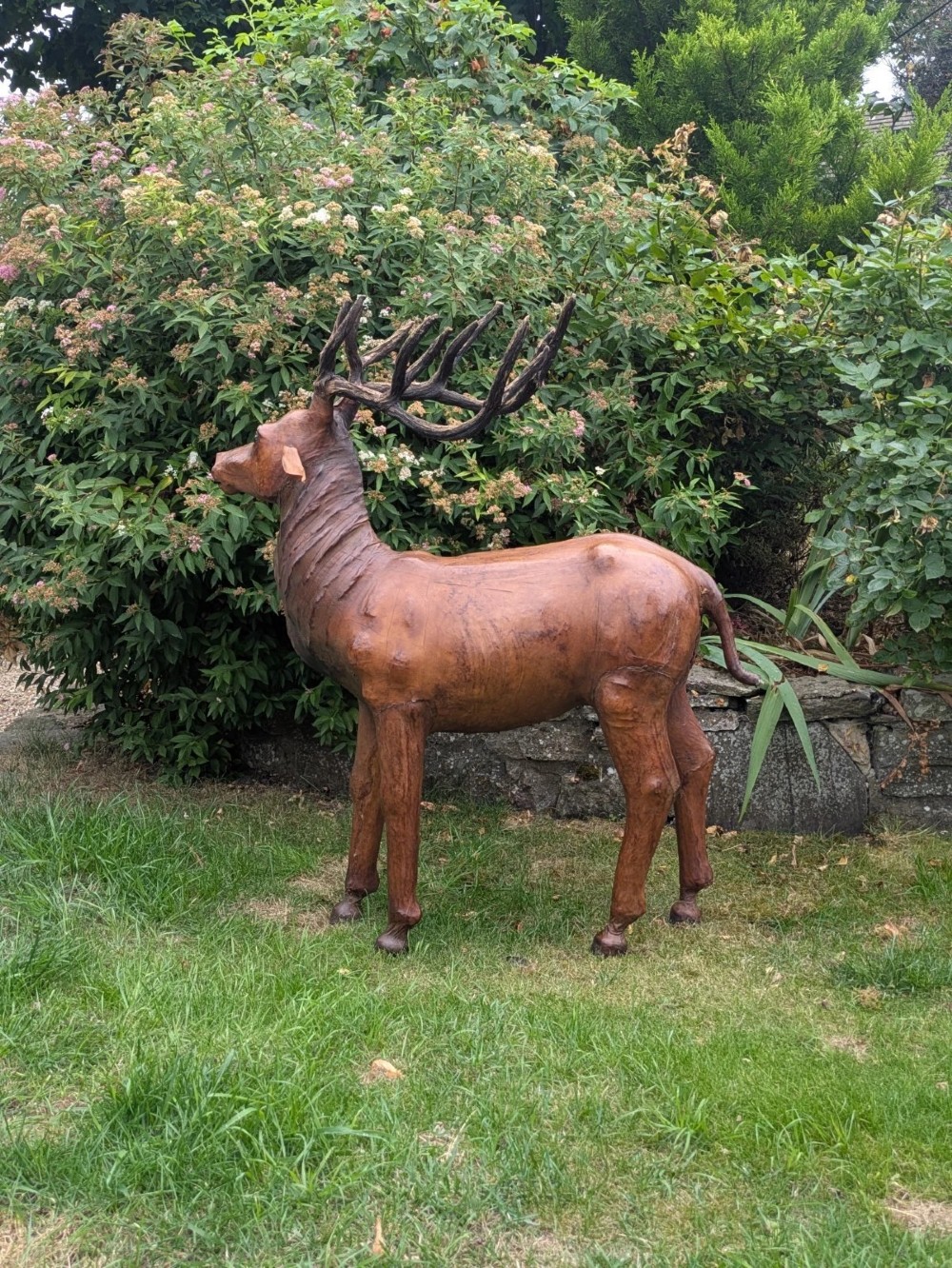 A life-like standing buck deer sculpture wrapped in warm brown stitched leather featuring large branching antlers and inset dark eyes. View XI