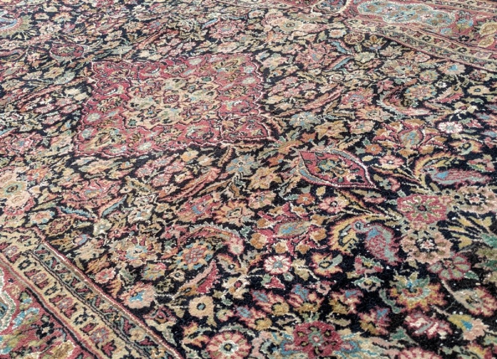 A hand-knotted Isfahan carpet featuring a detailed central medallion surrounded by floral scrollwork and cartouche borders in shades of rose, dark navy, cream, and turquoise. View VI