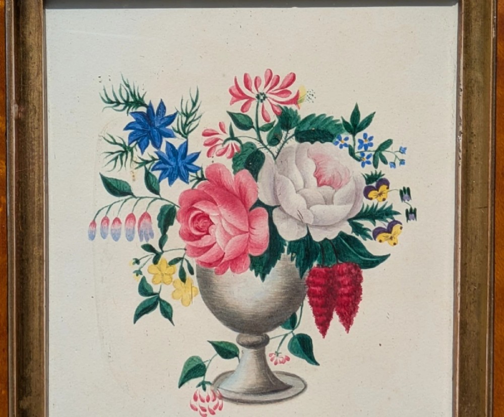 A framed Regency watercolour painting depicting a vibrant floral bouquet in an urn, set within a wide burr wood frame featuring a brass suspension ring. View III