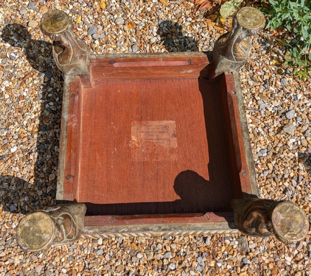 A square antique Indian low table with embossed brass and copper metal cladding, floral foliage motifs, a central geometric panel, and four claw feet. View VIII