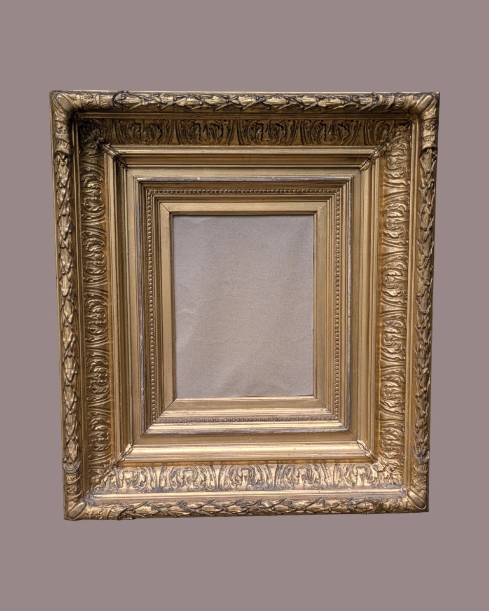 A matching pair of deep profile Victorian gilt picture frames featuring layered cove moulding and carved leaf border details. View II