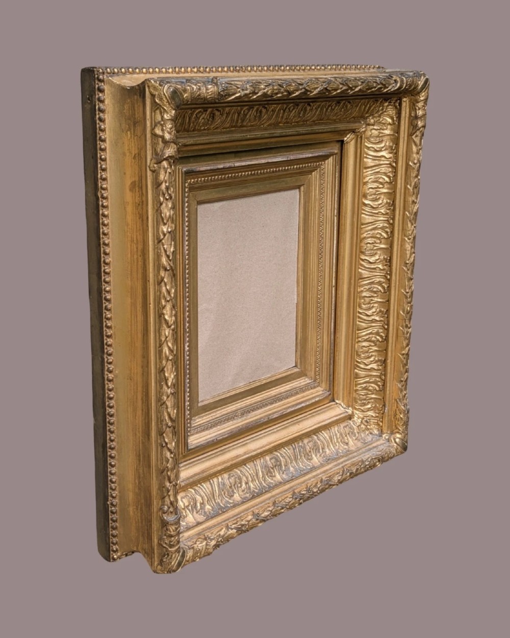 A matching pair of deep profile Victorian gilt picture frames featuring layered cove moulding and carved leaf border details. View III