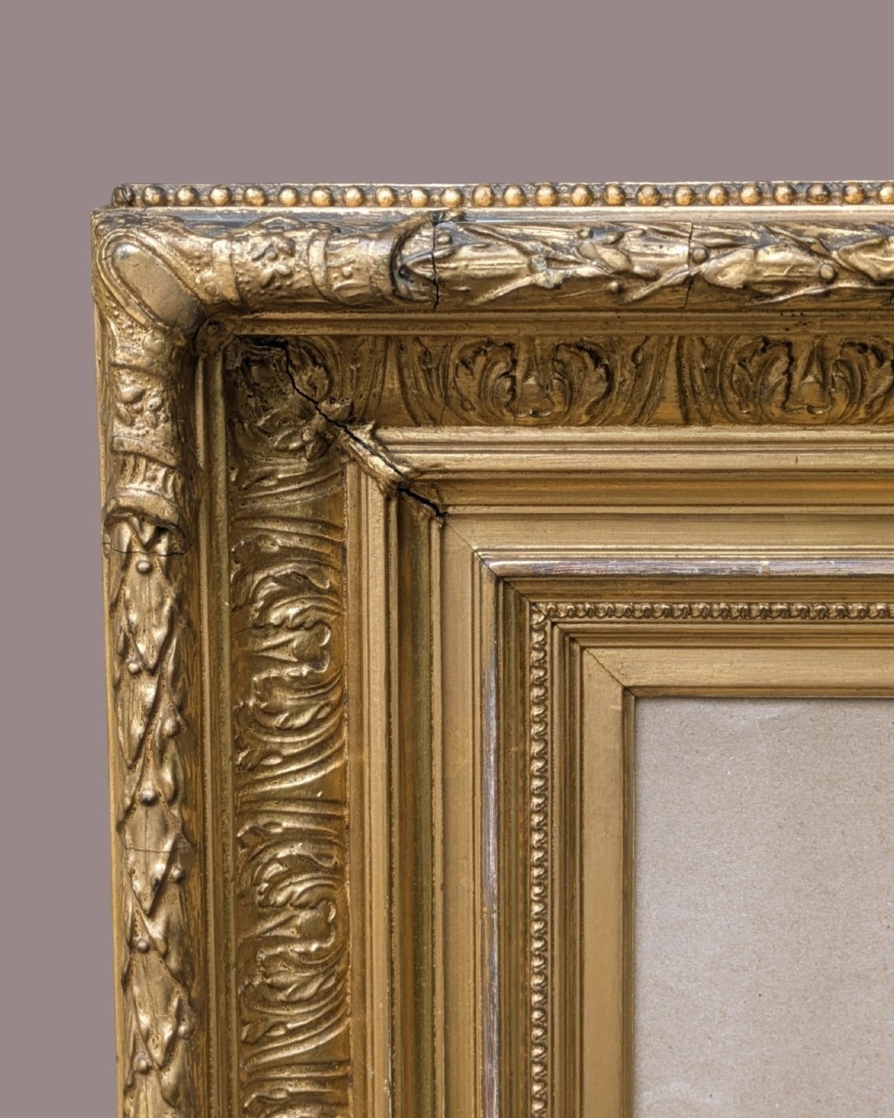 A matching pair of deep profile Victorian gilt picture frames featuring layered cove moulding and carved leaf border details. View VII
