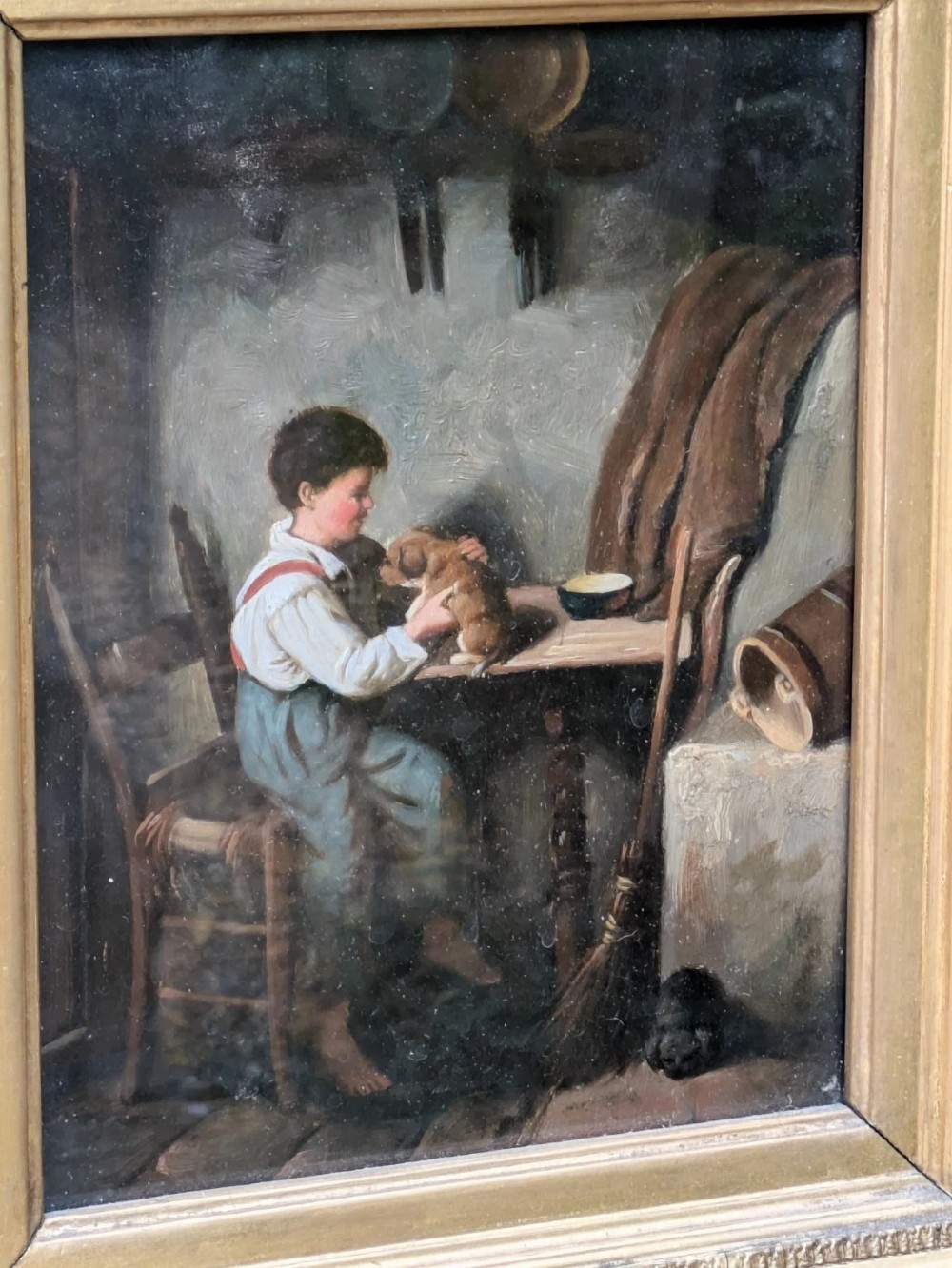 A pair of 19th-century oil paintings depicting young boys in rustic attire, mounted within deep, ornate gilded wooden frames. View VI