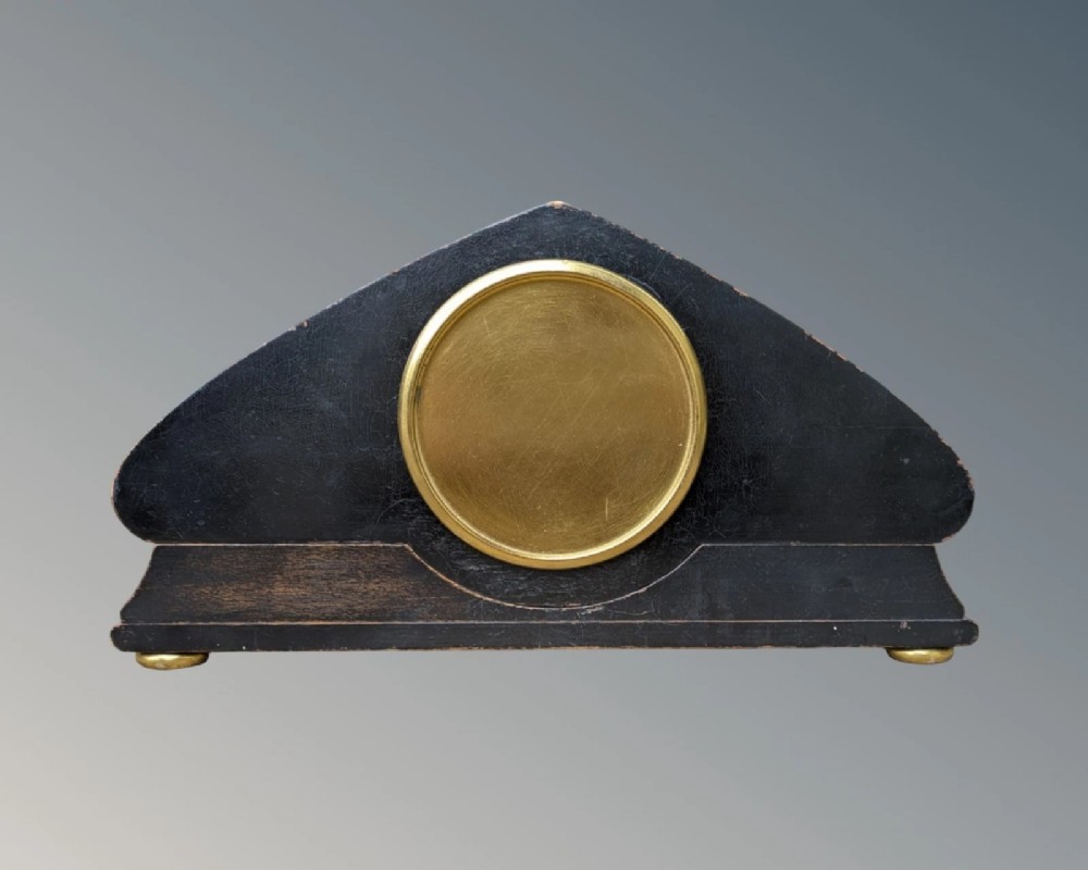 A black lacquered arched mantel clock featuring hand-painted gold Chinoiserie figures and landscapes surrounding a central brass dial. View VIII