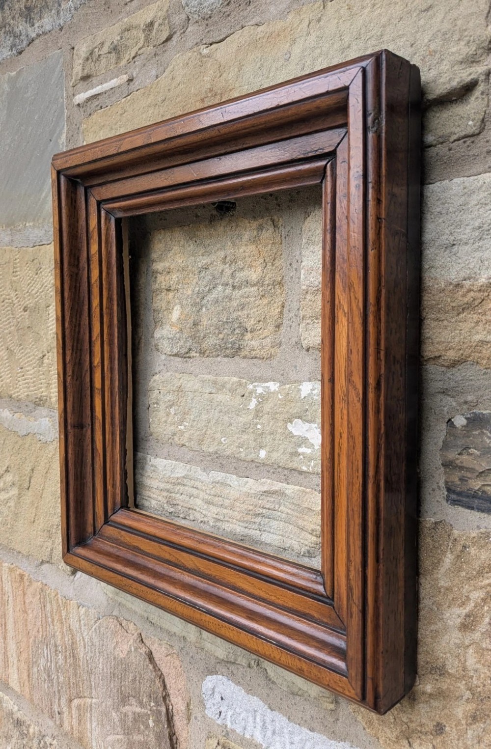 A rectangular antique solid walnut picture frame featuring multi-tiered moulding and mitred corners. View II