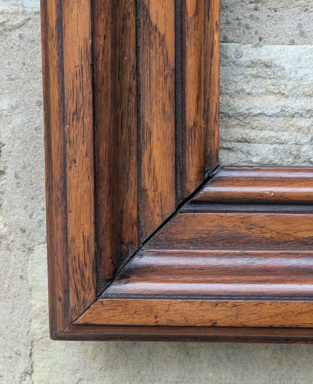 A rectangular antique solid walnut picture frame featuring multi-tiered moulding and mitred corners. View III