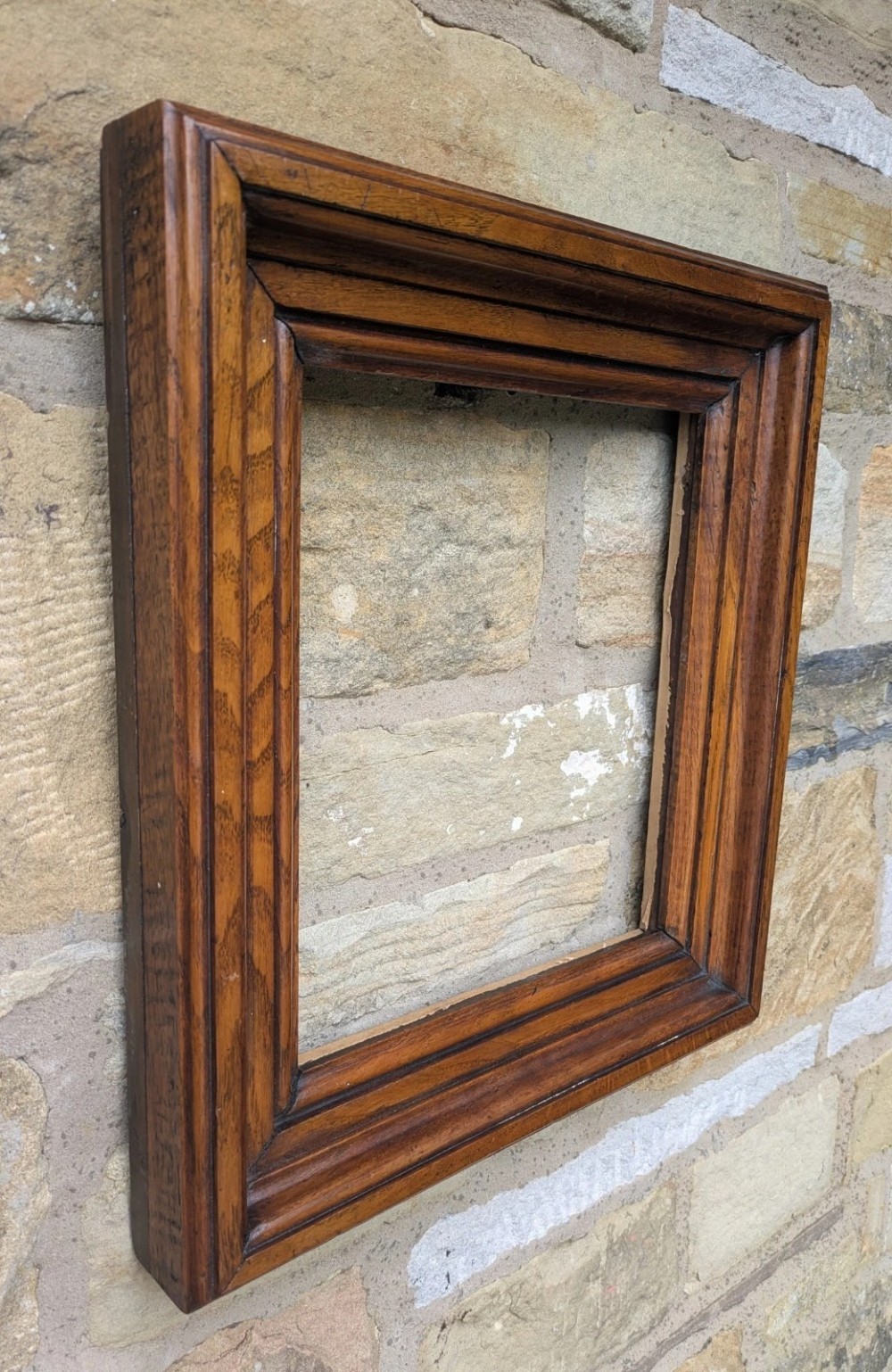 A rectangular antique solid walnut picture frame featuring multi-tiered moulding and mitred corners. View V