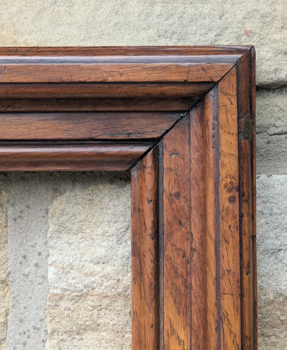A rectangular antique solid walnut picture frame featuring multi-tiered moulding and mitred corners. View VI