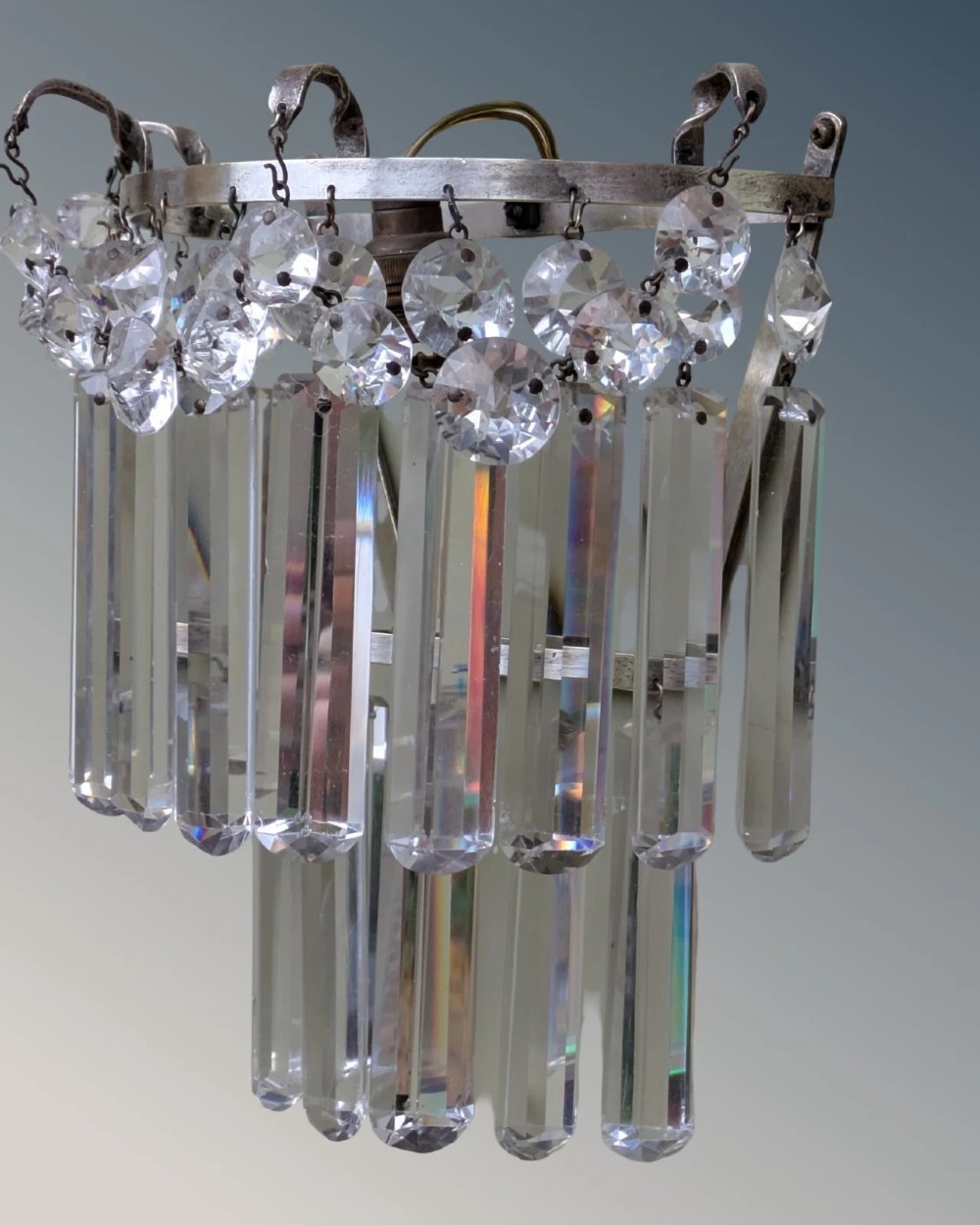 A pair of semi-circular wall lights featuring cascading tiers of clear cut crystal rectangular prisms suspended from silver-toned metal frames. View IV