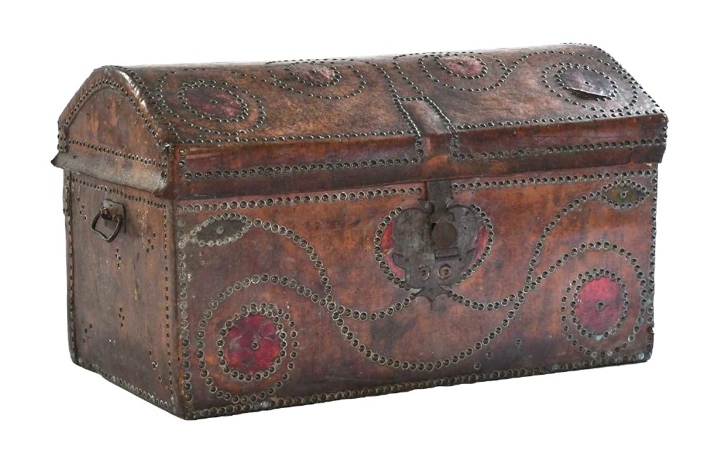 An 18th-century George II brown leather trunk embellished with decorative brass studding, iron side handles, and an open hinged lid revealing a printed floral paper interior. View II