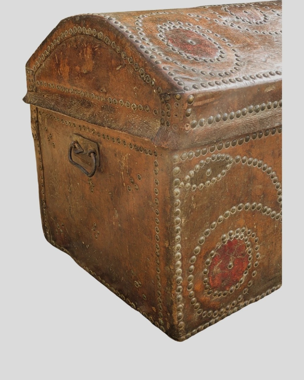 An 18th-century George II brown leather trunk embellished with decorative brass studding, iron side handles, and an open hinged lid revealing a printed floral paper interior. View IV
