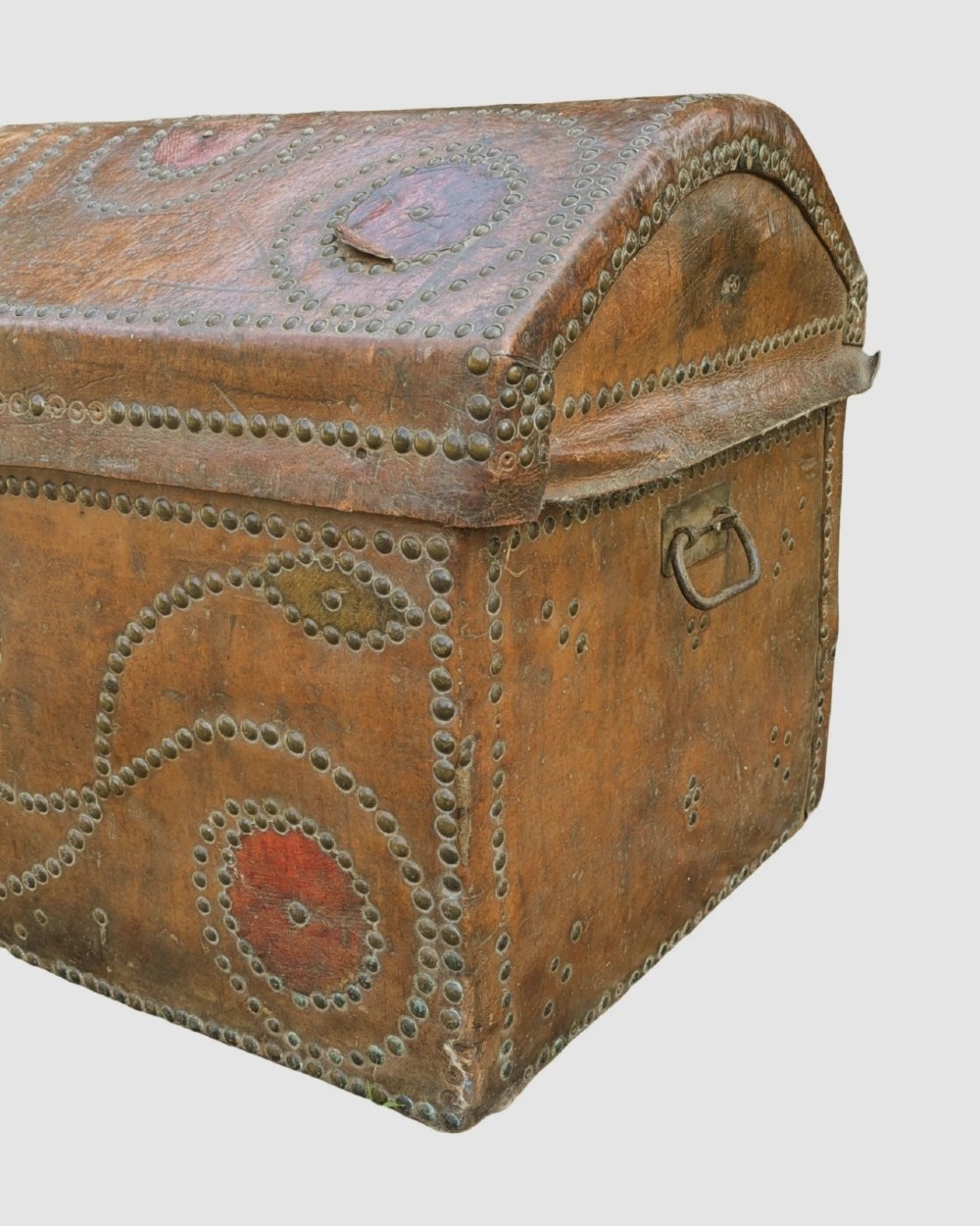 An 18th-century George II brown leather trunk embellished with decorative brass studding, iron side handles, and an open hinged lid revealing a printed floral paper interior. View V