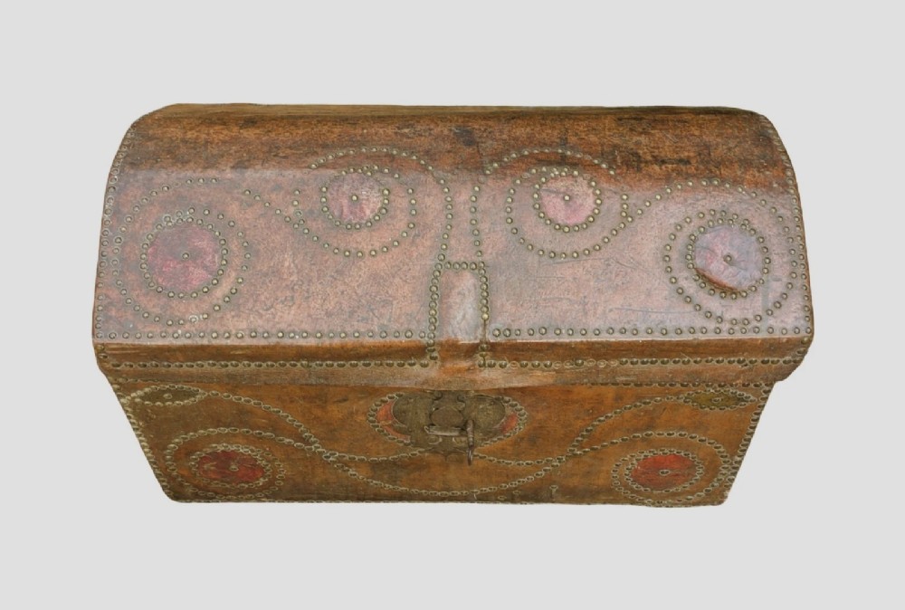 An 18th-century George II brown leather trunk embellished with decorative brass studding, iron side handles, and an open hinged lid revealing a printed floral paper interior. View VI