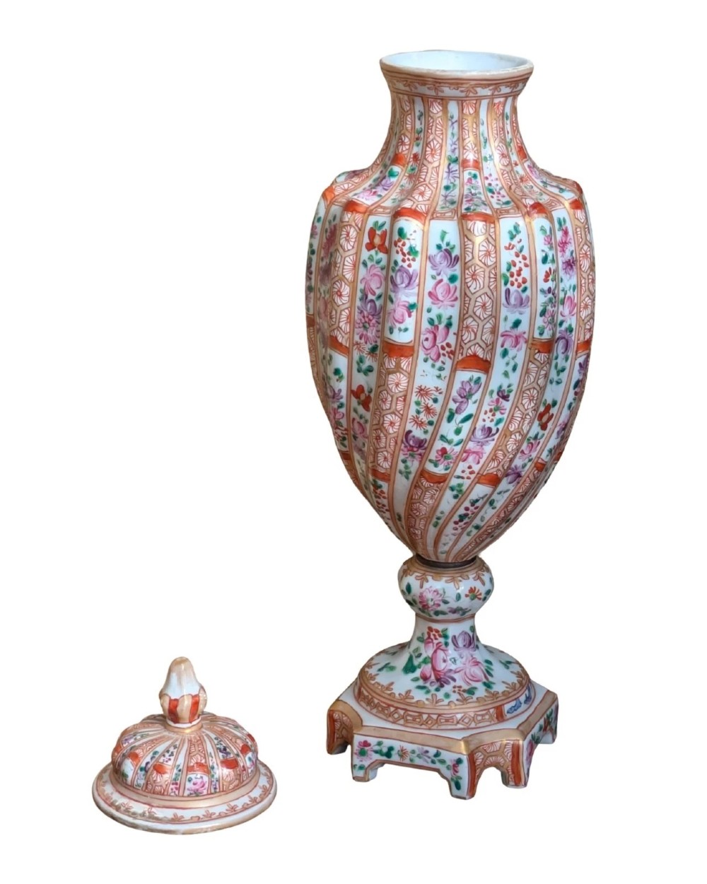 A pair of hand-painted porcelain lidded vases featuring fluted bodies, intricate floral motifs, geometric orange bands, and gilded details on square pedestals. View XI
