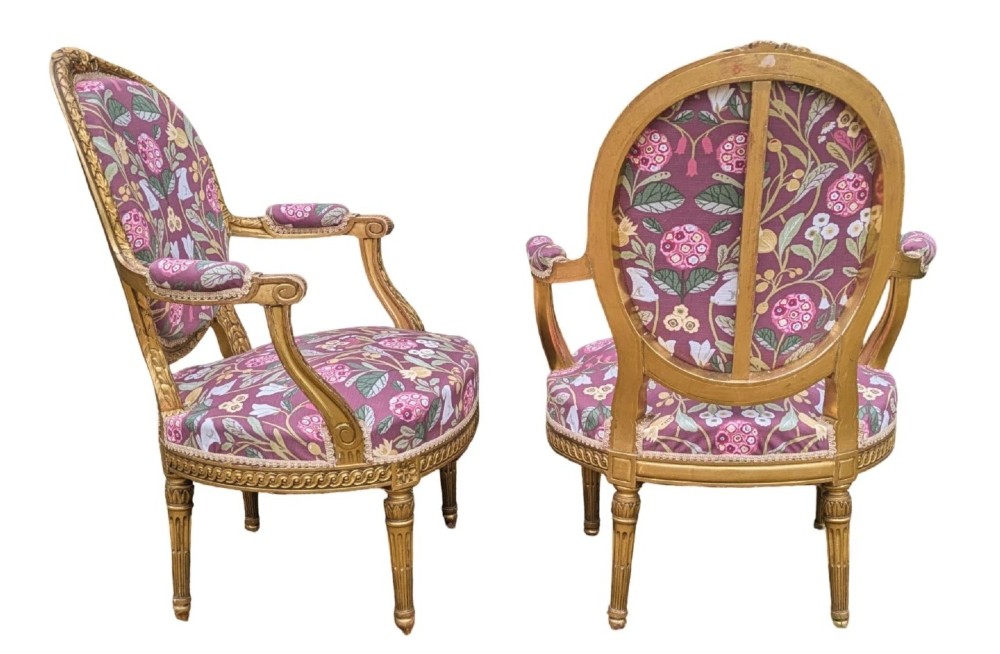 A pair of carved giltwood French armchairs featuring oval medallion backs and floral patterned plum-coloured upholstery. View V