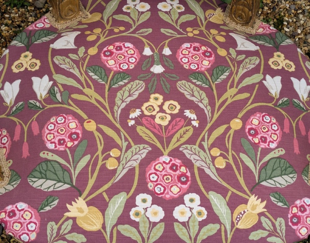 A pair of carved giltwood French armchairs featuring oval medallion backs and floral patterned plum-coloured upholstery. View X