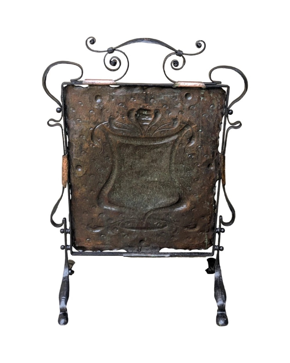 An Arts and Crafts fire screen constructed from a hand-hammered copper central panel with raised relief decoration, held within a black wrought iron scrollwork frame. View VII
