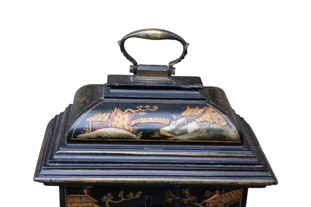 A black lacquered Regency style mantel clock decorated with gold hand-painted Chinoiserie landscapes, featuring a white circular dial with Arabic numerals and a top brass handle. View VI