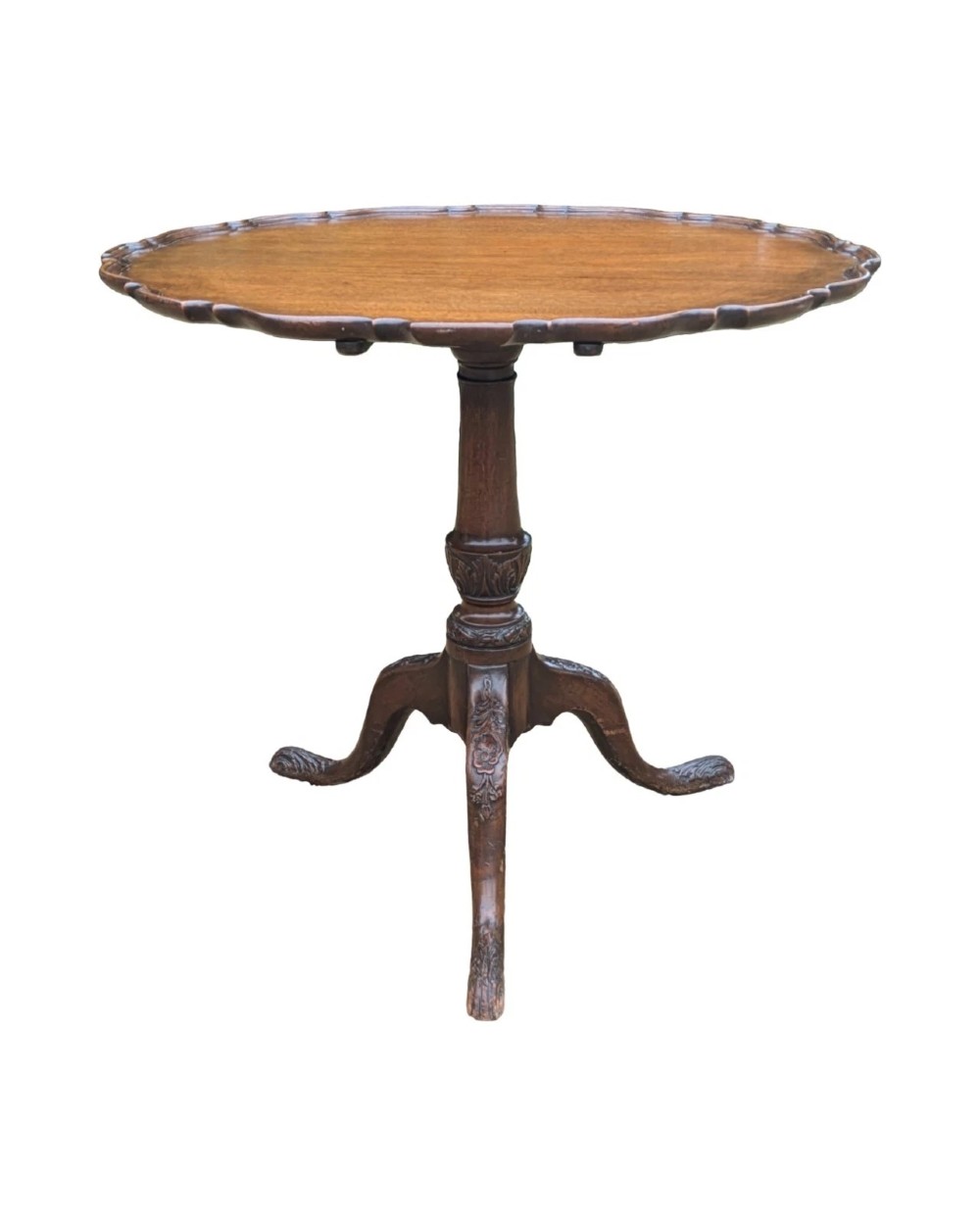 A Georgian mahogany tilt-top table with a scalloped piecrust edge shown in a raised vertical position above a turned pedestal and carved tripod cabriole legs. View III