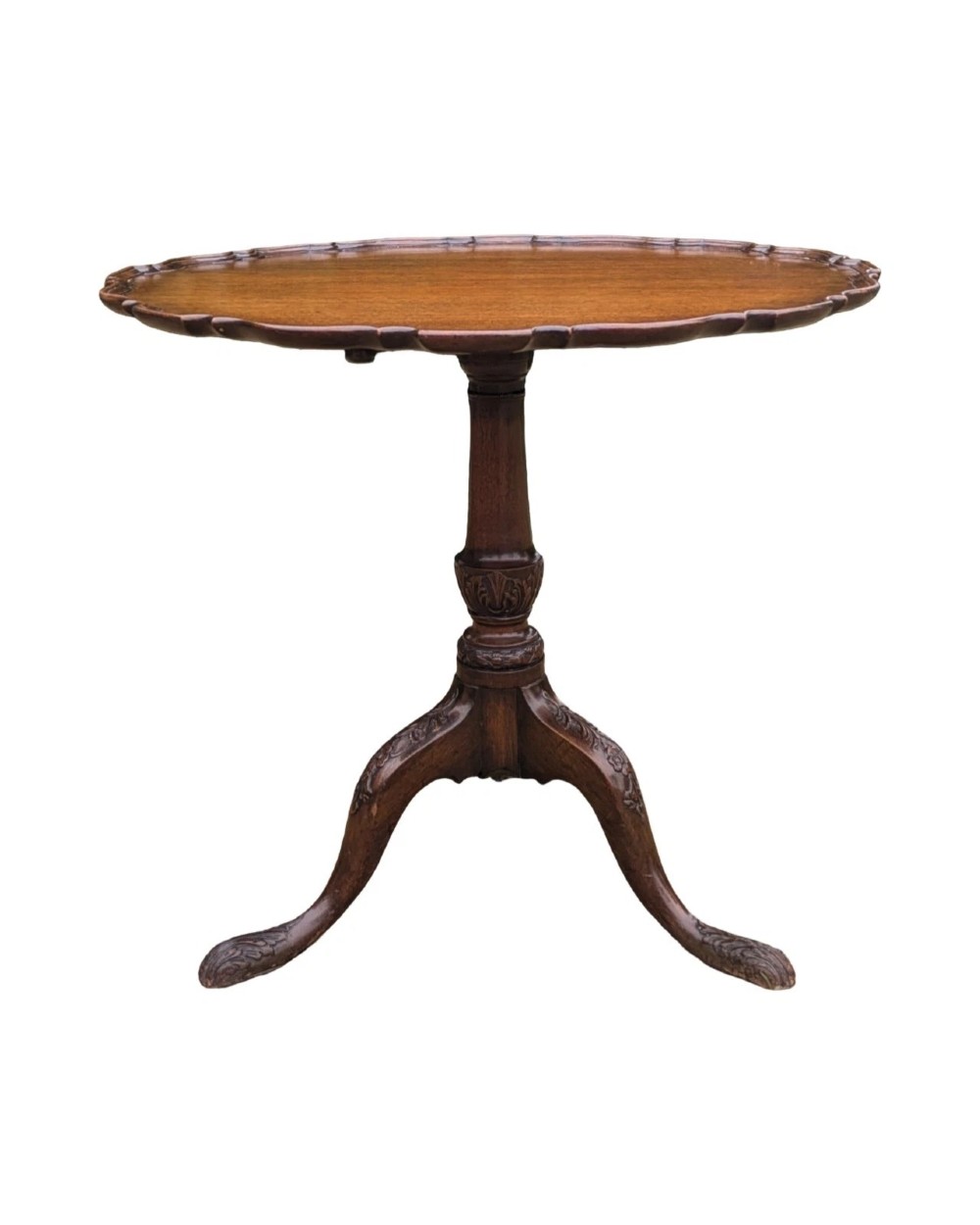 A Georgian mahogany tilt-top table with a scalloped piecrust edge shown in a raised vertical position above a turned pedestal and carved tripod cabriole legs. View VI