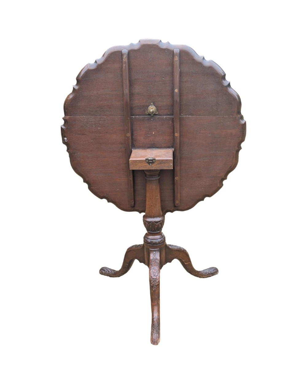A Georgian mahogany tilt-top table with a scalloped piecrust edge shown in a raised vertical position above a turned pedestal and carved tripod cabriole legs. View VIII
