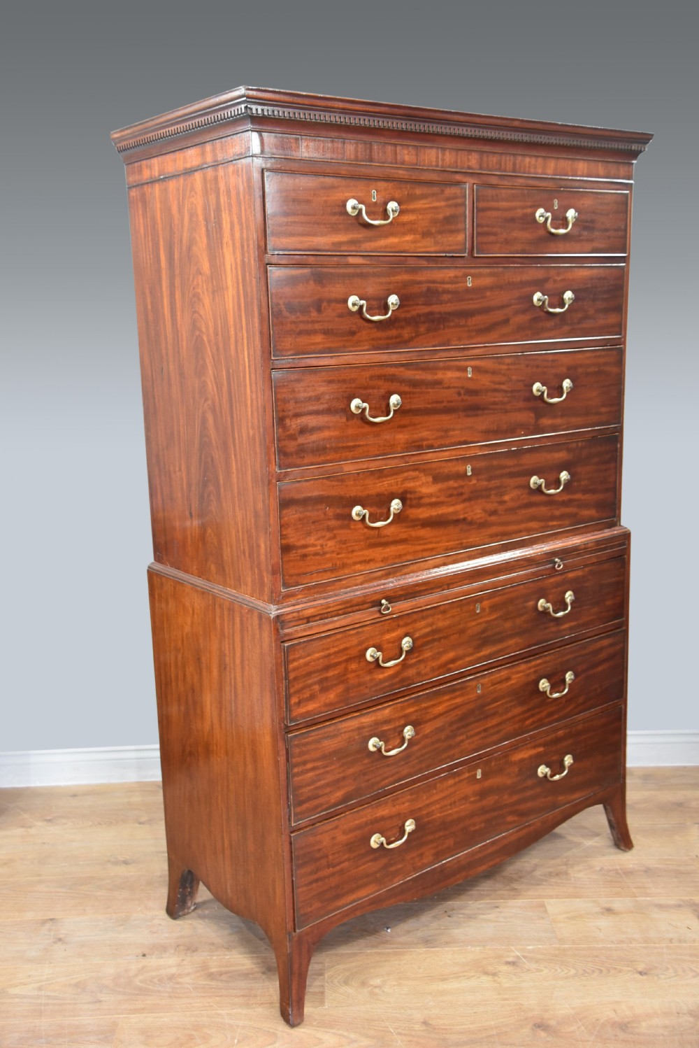 A Georgian mahogany chest on chest featuring two stacked drawer sections, brass swan-neck handles, a dentil cornice, and splayed bracket feet. View III