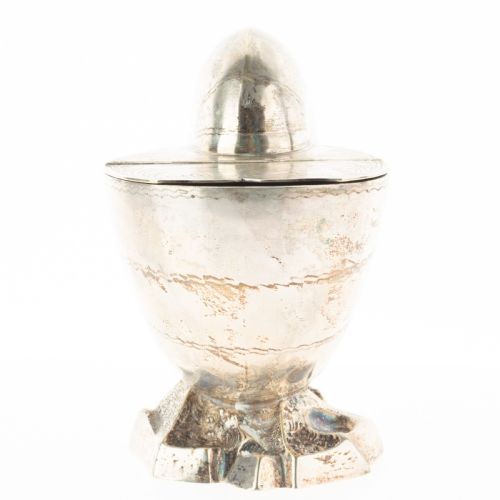fig 1. A Victorian silver-plated spoon warmer fashioned in the shape of a nautilus shell with engraved detailing and a hinged lid, resting on a textured base.