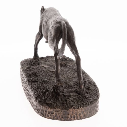 fig 1. A dark patinated bronze sculpture capturing a greyhound in full stride mounted on a textured oval base.