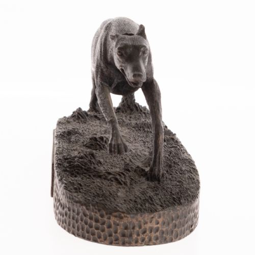 fig 3. A dark patinated bronze sculpture capturing a greyhound in full stride mounted on a textured oval base.