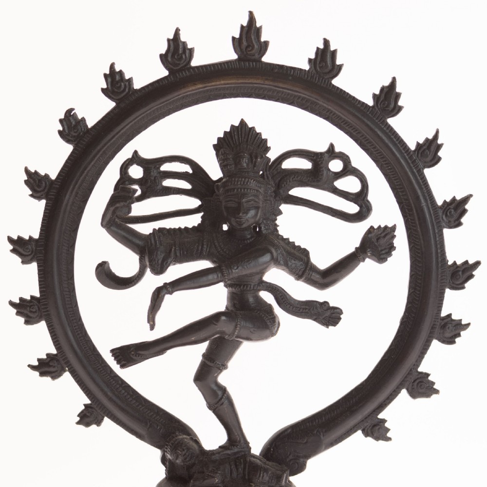 A dark patinated bronze sculpture depicting the Hindu deity Shiva Nataraja as the cosmic dancer encircled by a flaming halo atop a tiered square pedestal. View II