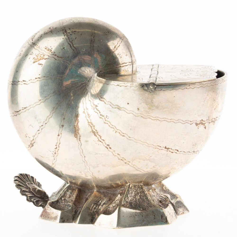 A Victorian silver-plated spoon warmer fashioned in the shape of a nautilus shell with engraved detailing and a hinged lid, resting on a textured base.
