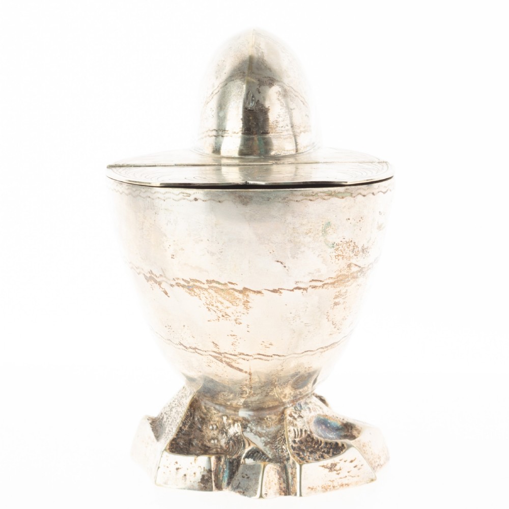 A Victorian silver-plated spoon warmer fashioned in the shape of a nautilus shell with engraved detailing and a hinged lid, resting on a textured base. View II
