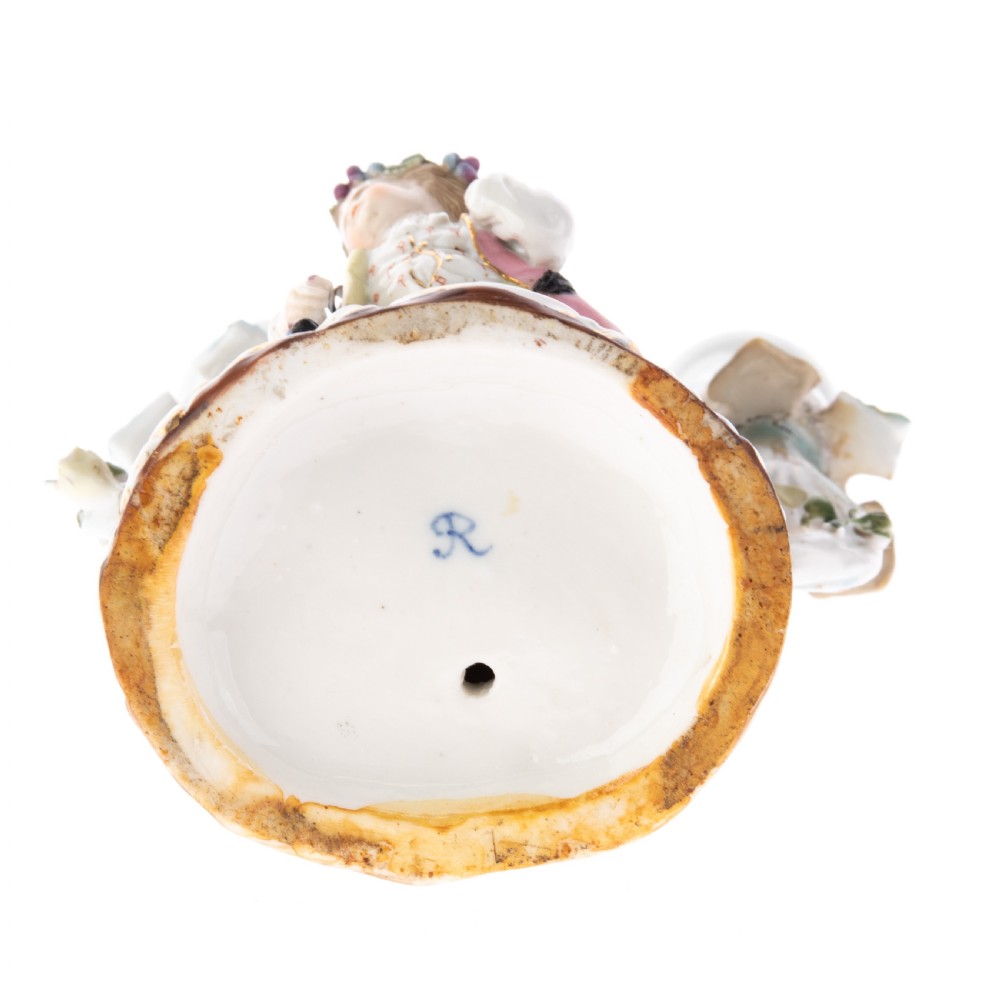 A Dresden porcelain two-light figural candelabrum featuring a youth surrounded by encrusted floral displays and gilt-accented Rococo branch sconces. View II