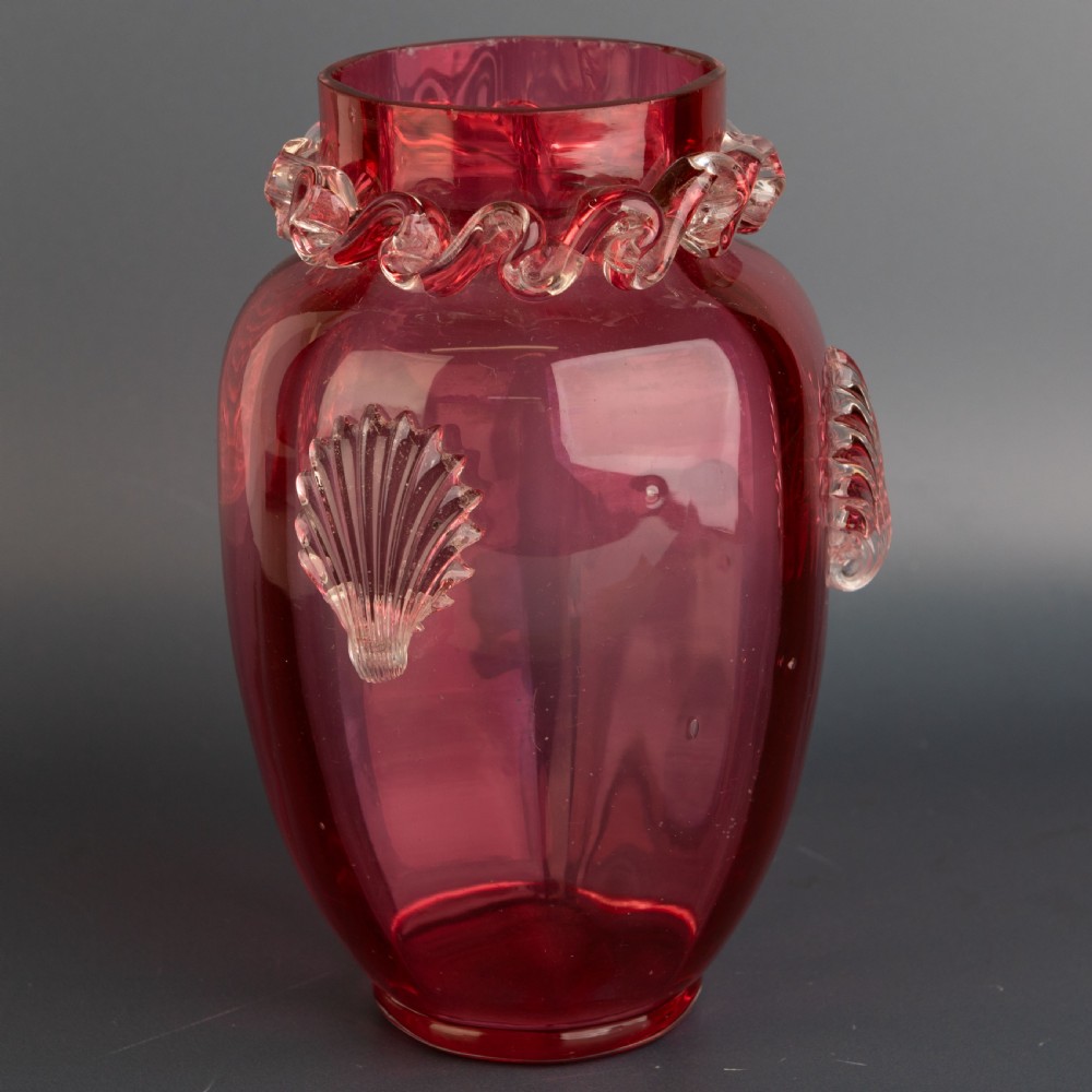 A Victorian hand-blown cranberry glass vase featuring an applied clear glass shell motif on the front and a crimped clear glass collar around the neck. View II