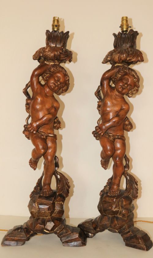A Large Pair of Carved Wooden Cherub Lamps