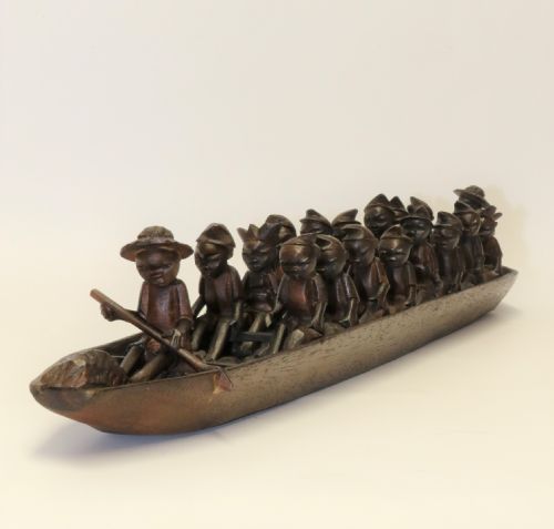 An African Carved Wooden Model of a Dug-out Canoe with 18 Seated Tribal Figures.