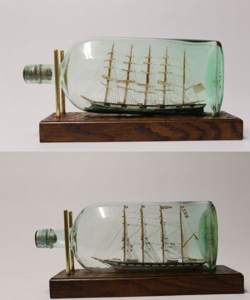 A Rare Pair of Early 20th Century Model Sailing Ships in Bottles Displayed on Wooden Stands
