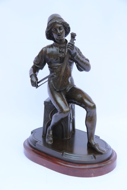 A FINE 19TH CENTURY FRENCH BRONZE STUDY OF A MEDIEVAL SEATED MUSICIAN PLAYING AN EARLY STRING INSTRUMENT WITH A BOW