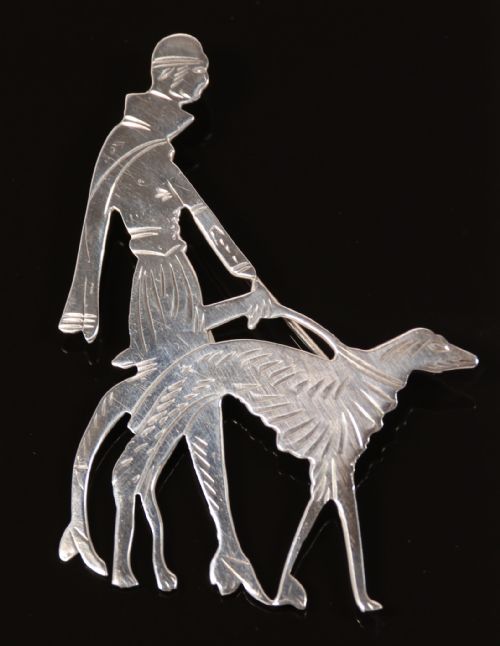 An Art Deco Silver Brooch  in the Form of an Elegant 1920s Lady Walking Her Borzoi Dog.