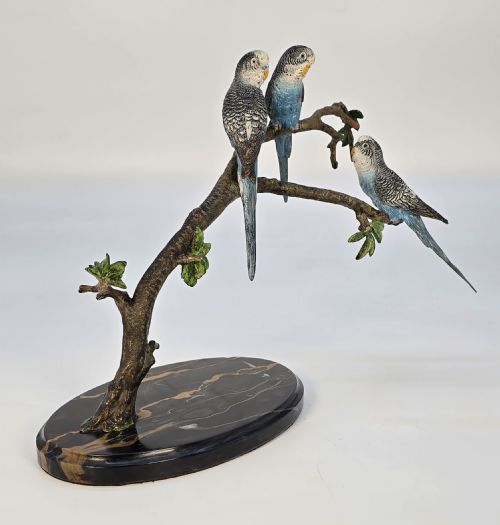 fig 1. A cold painted bronze sculpture depicting three blue budgerigars perched on a branch mounted on an oval dark marble base.
