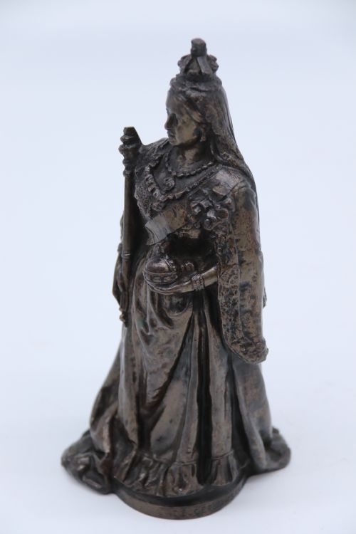 fig 2. A dark patinated bronze statuette depicting Queen Victoria standing in full ceremonial robes, wearing a crown and holding a sceptre and orb.