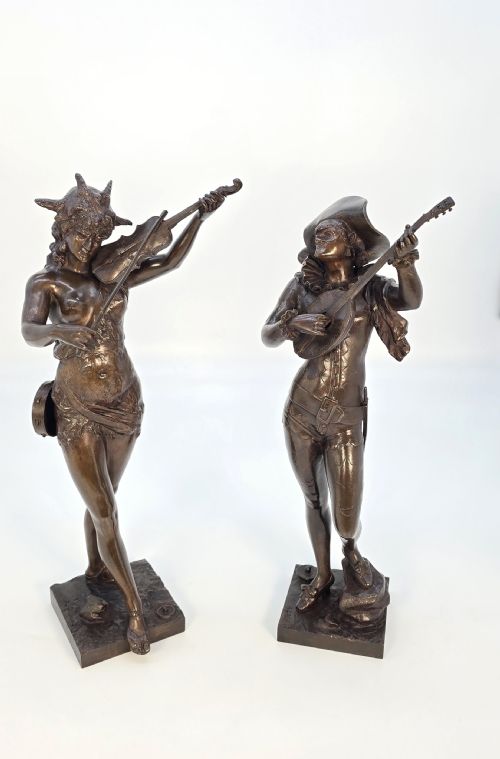 fig 1. A pair of late 19th-century bronze statuettes depicting theatrical figures playing stringed musical instruments on square bases.